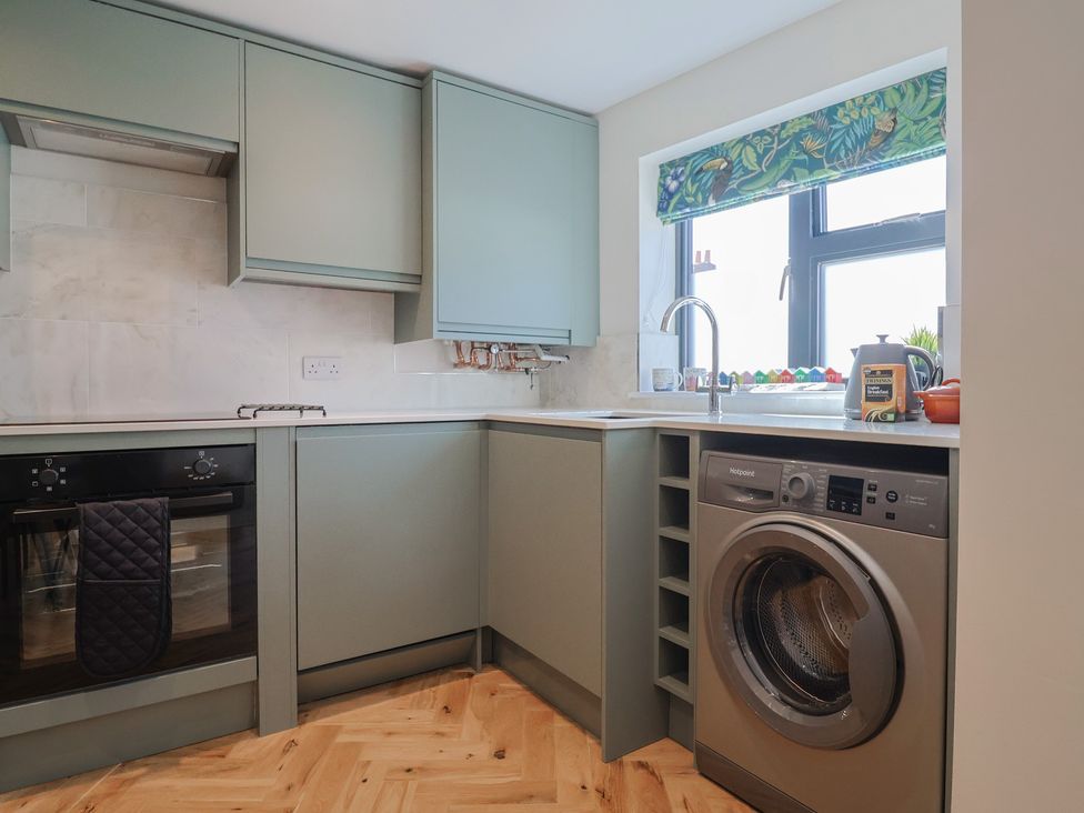 A kitchen with oven, sink, and washing machine at 1 Mill Green Court, Lyme Regis