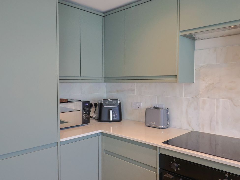 A kitchen with cabinets, microwave, toaster, and coffee maker at 1 Mill Green Court Lyme Regis