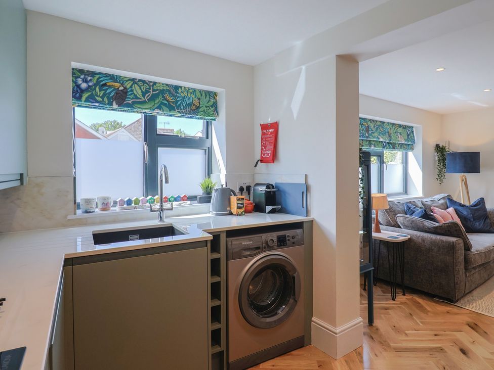 A kitchen with a washing machine and window at 1 Mill Green Court in Lyme Regis