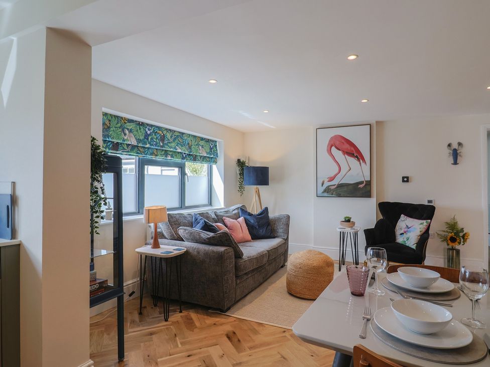 A living room with a sofa and dining table at 1 Mill Green Court Lyme Regis