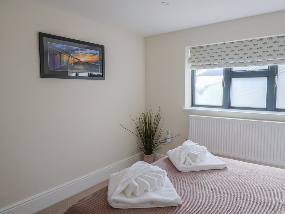 A bedroom with towels on a bed at 1 Mill Green Court in Lyme Regis