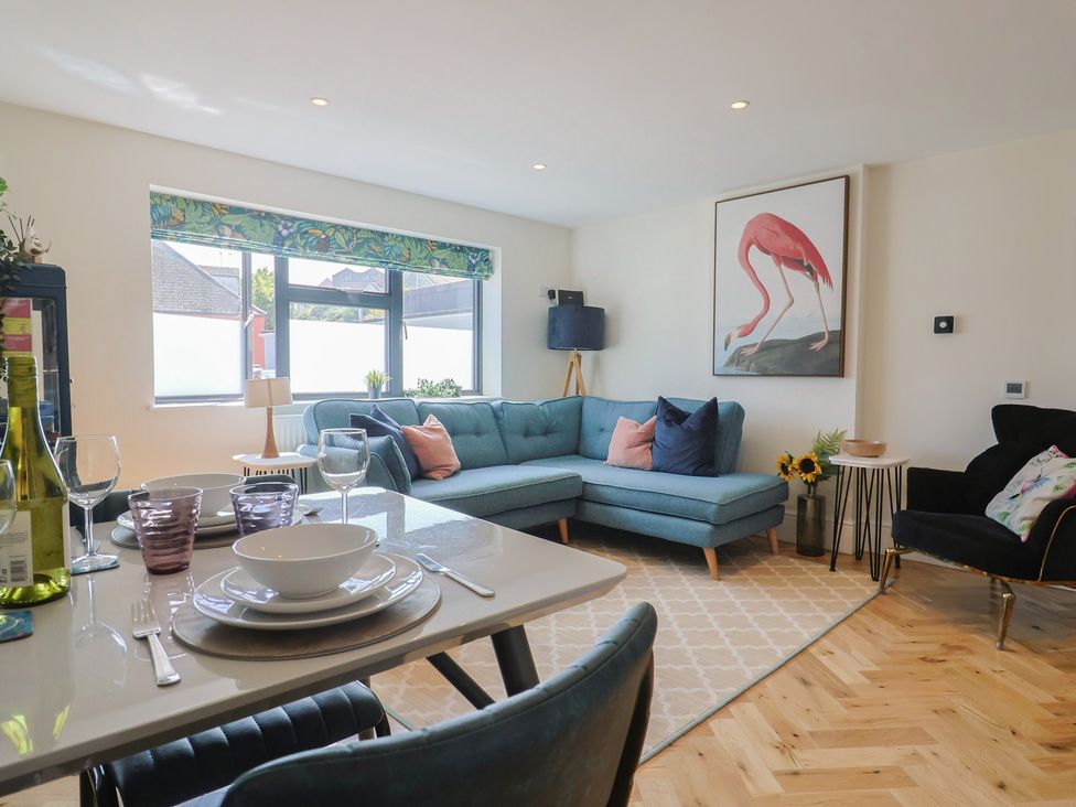 A living room with a sofa and dining table at 1 Mill Green Court in Lyme Regis