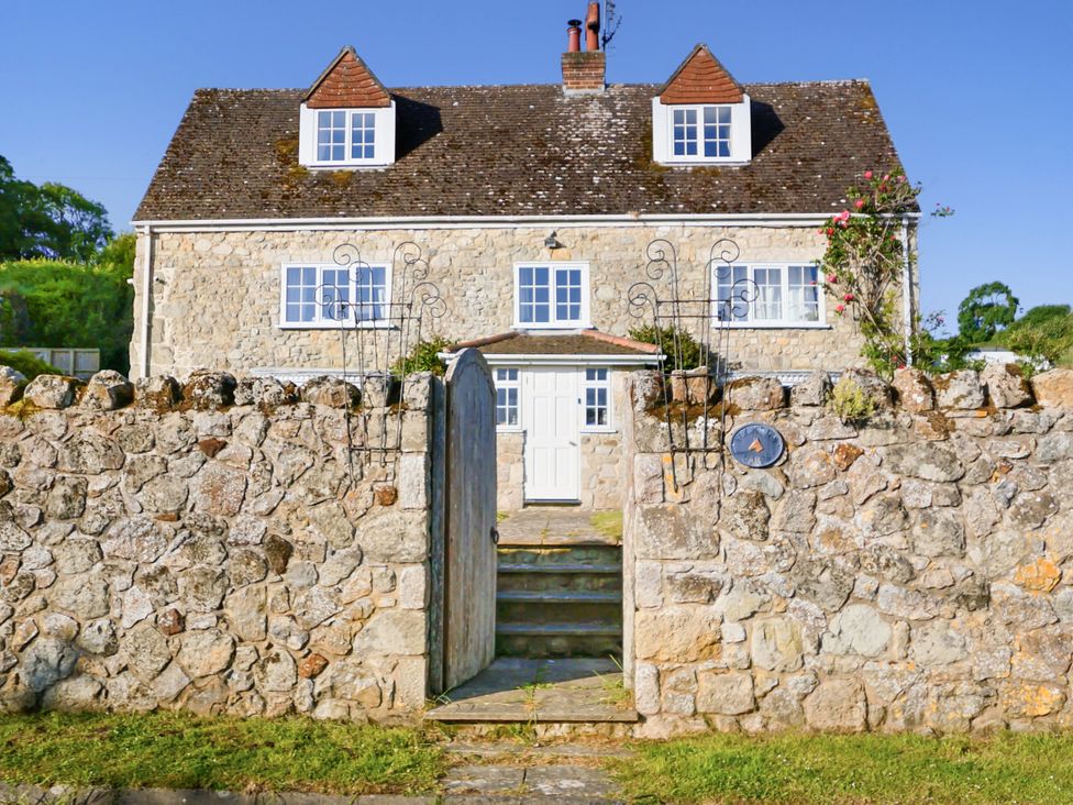 A stone house with a garden and steps at Tuckers Farm in Gatcombe