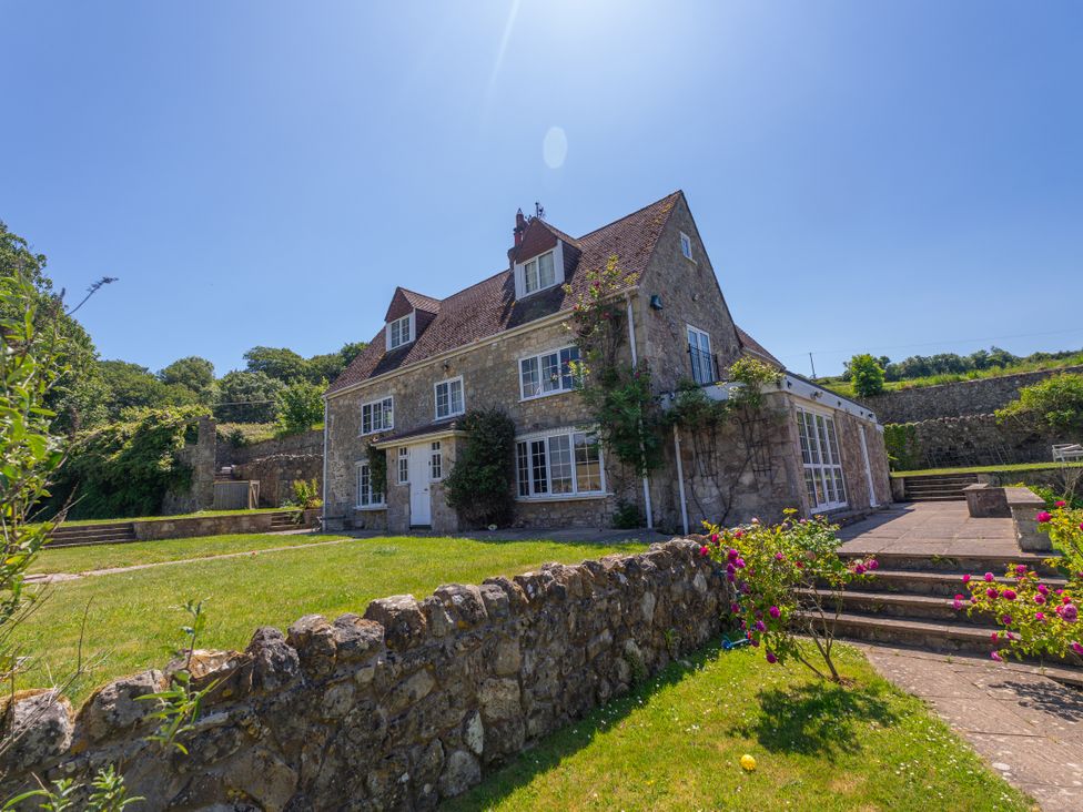 A house with windows and a garden area at Tuckers Farm in Gatcombe
