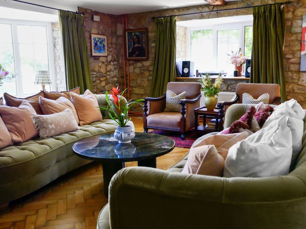 A living room with sofas, armchairs, and a coffee table at Tuckers Farm Gatcombe