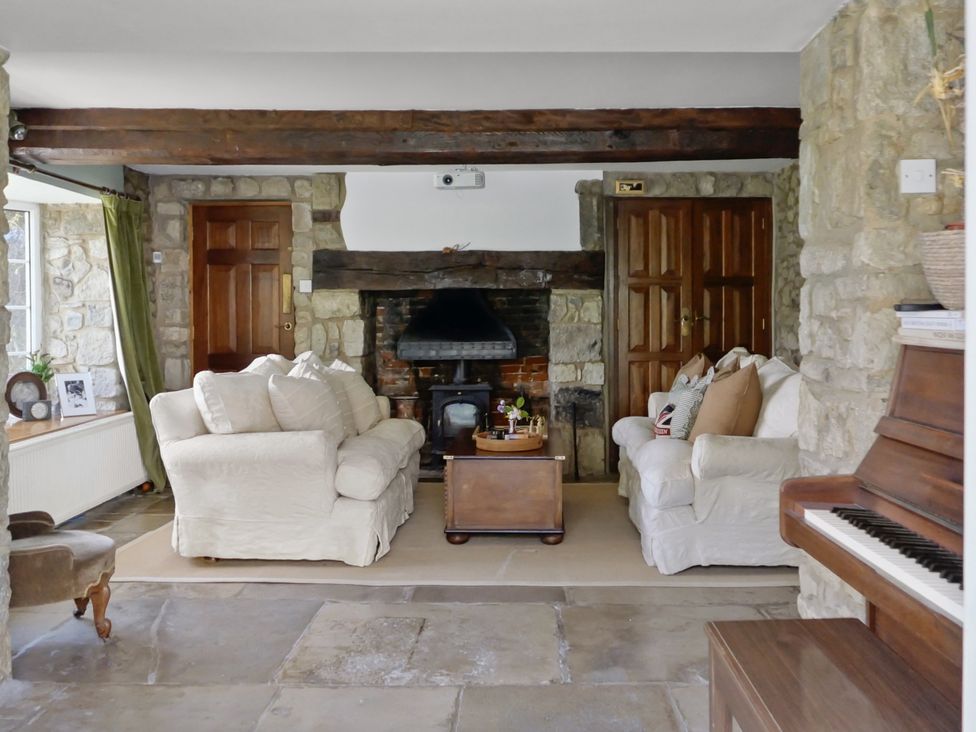 A living room with a fireplace and sofas at Tuckers Farm in Gatcombe
