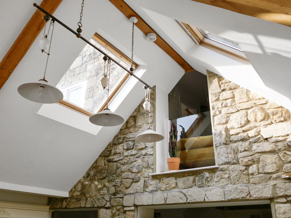 A room with a skylight and stone wall at Tuckers Farm in Gatcombe