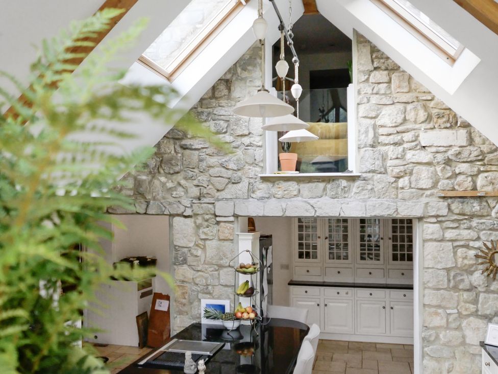 A kitchen with a stone wall and skylight at Tuckers Farm in Gatcombe