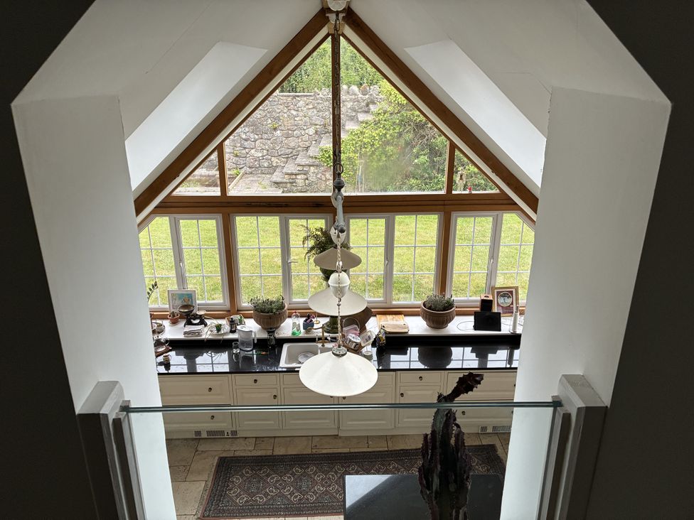 A kitchen with large windows, counter space and a sink at Tuckers Farm in Gatcombe