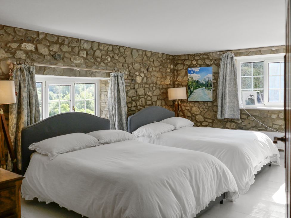 A bedroom with two beds and a window at Tuckers Farm in Gatcombe