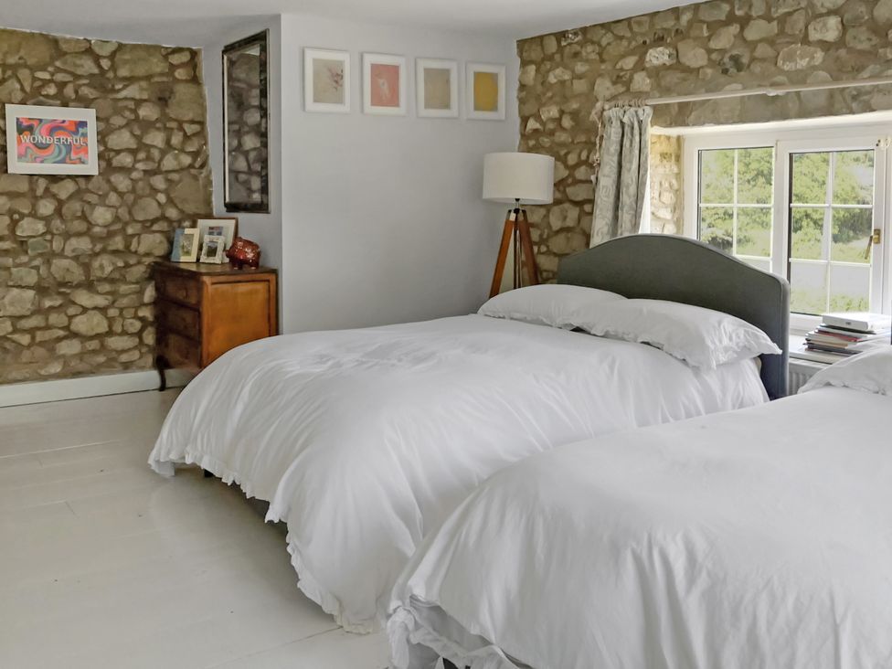 A bedroom with two beds and a lamp at Tuckers Farm in Gatcombe