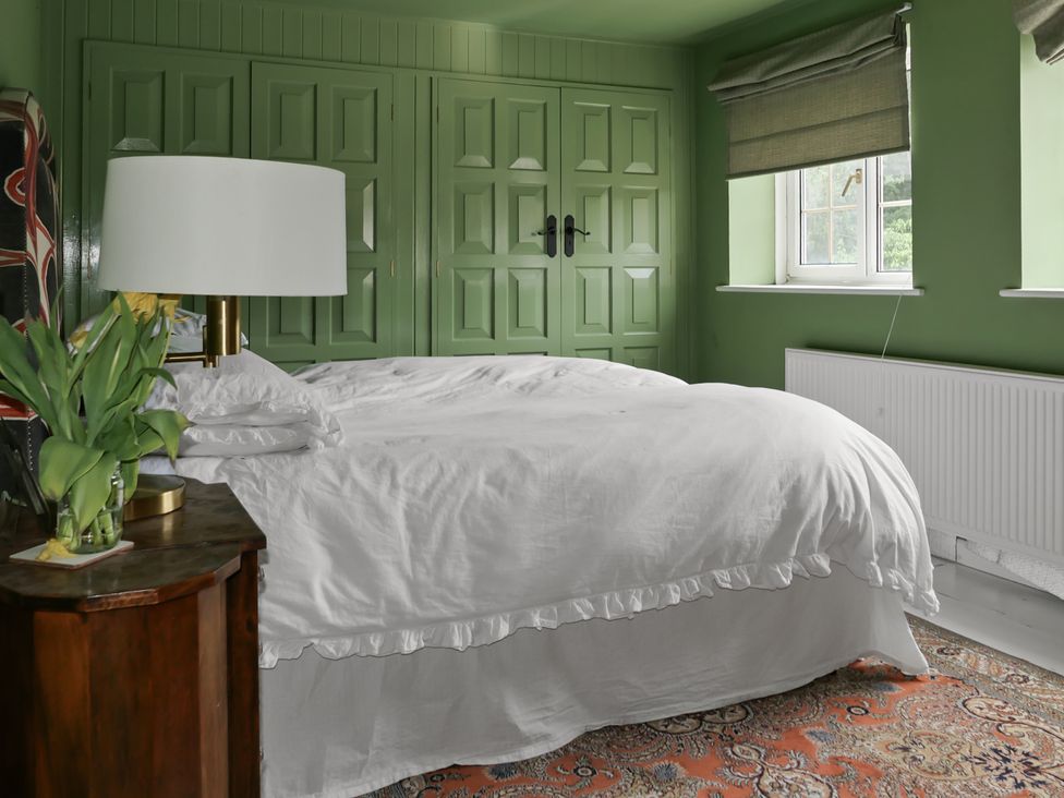 A bedroom with a bed and nightstand at Tuckers Farm in Gatcombe