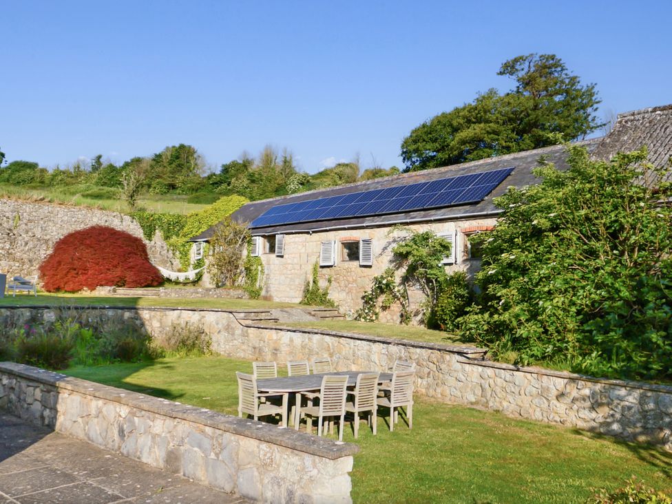 A garden with solar panels and outdoor furniture at Tuckers Farm in Gatcombe