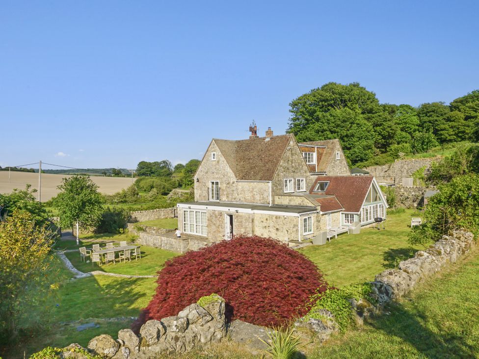 A house with a garden and seating area at Tuckers Farm in Gatcombe