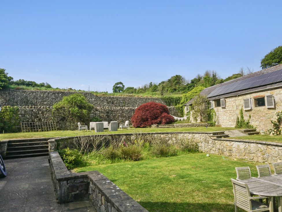 A garden with stone walls and seating at Tuckers Farm in Gatcombe