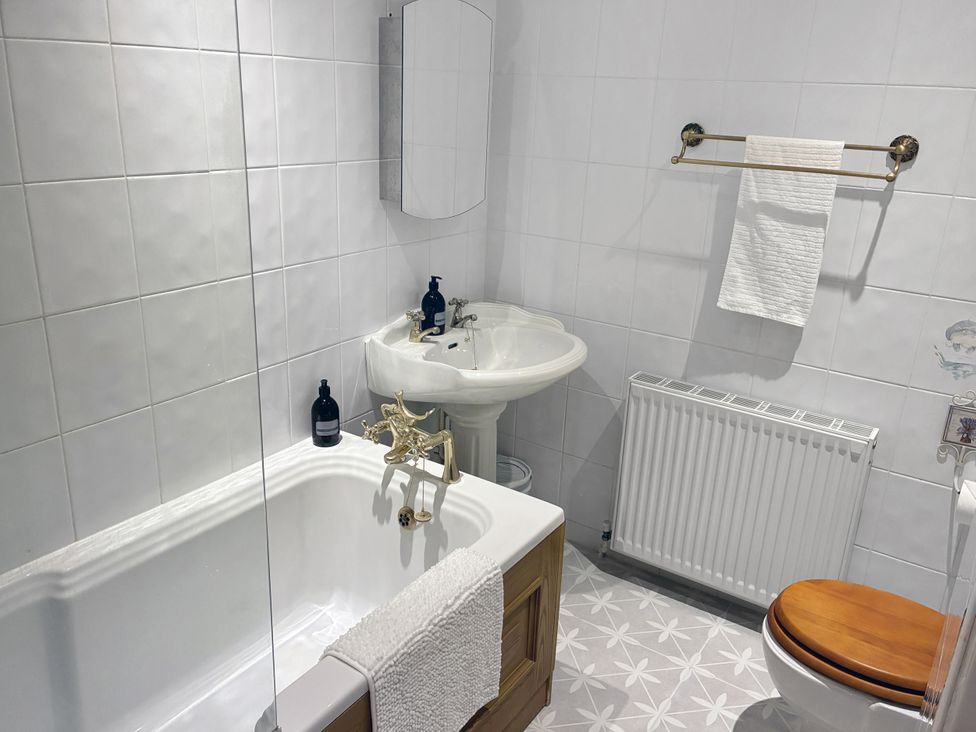 A bathroom with a bathtub, sink, and toilet at Tuckers Farm in Gatcombe