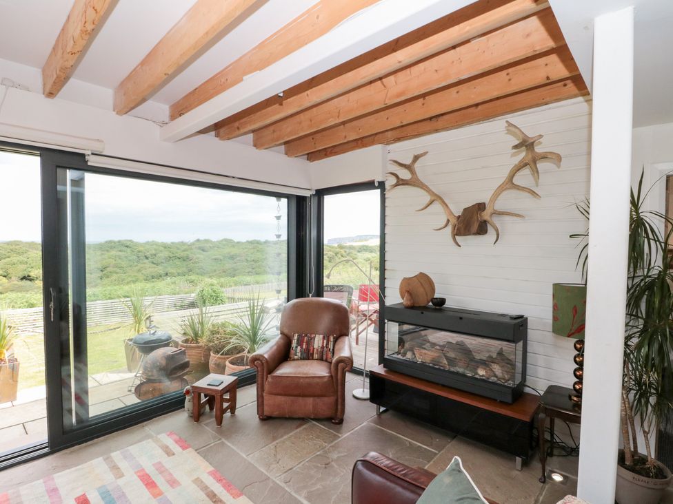 A living room with a chair and fireplace at Sea Haven near Hunmanby Gap