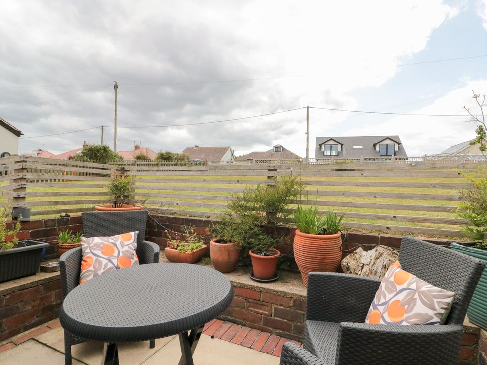 An outdoor seating area with a table and plant pots at Sea Haven in Hunmanby Gap near Primrose Valley