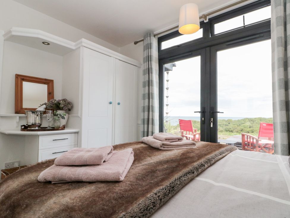 A bedroom with a bed, towels on it, and a window at Sea Haven Hunmanby Gap near Primrose Valley