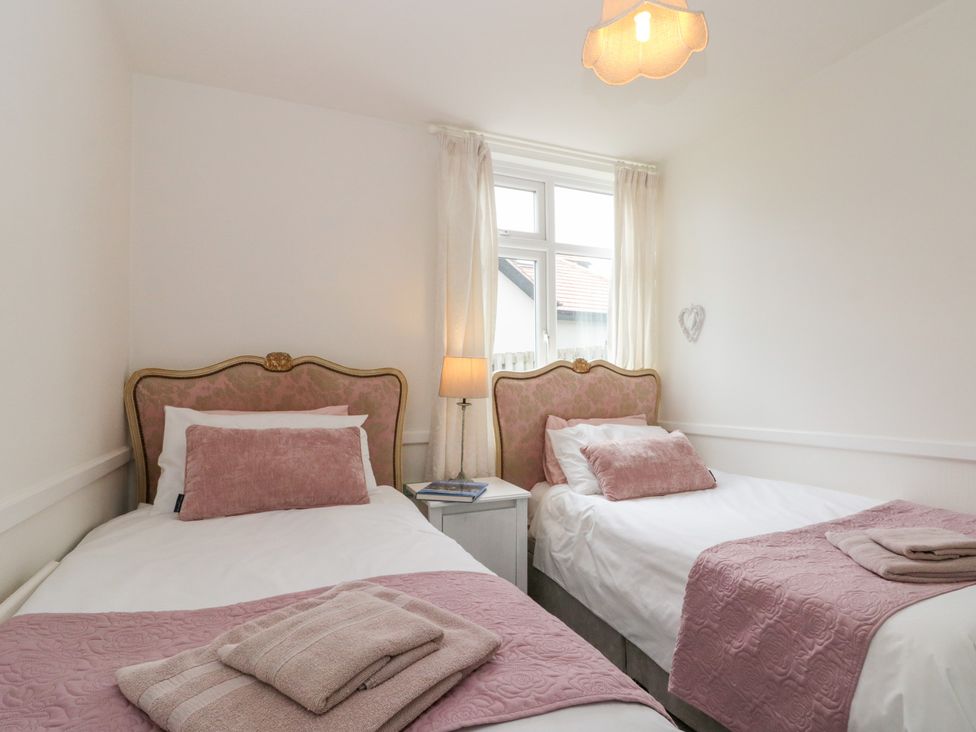 A bedroom with two beds and a lamp at Sea Haven near Hunmanby Gap
