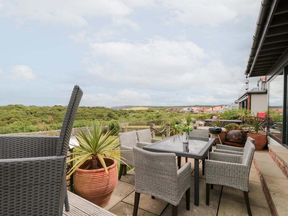 An outdoor seating area with a table and chairs at Sea Haven near Hunmanby Gap