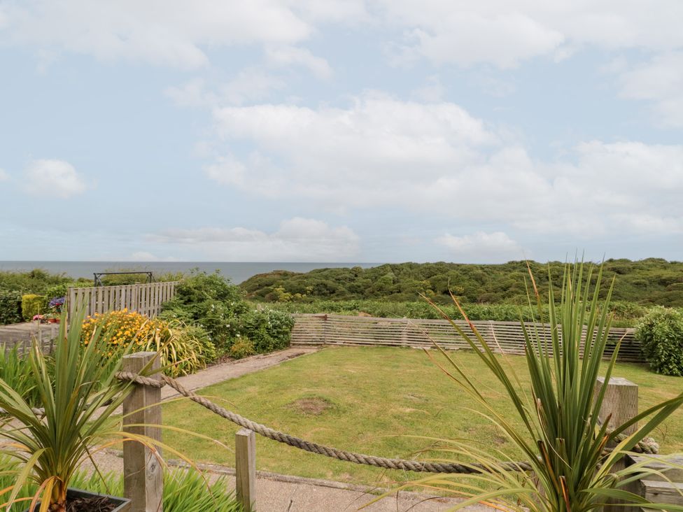 A garden with grass and plants overlooking the sea at Sea Haven near Hunmanby Gap