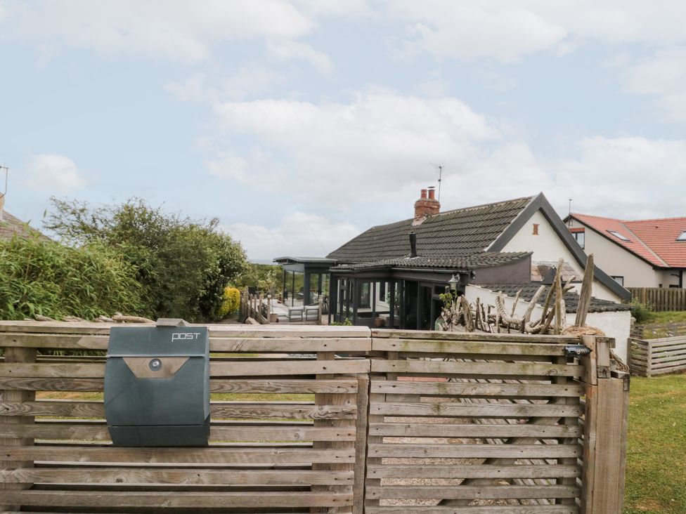A garden with a mailbox and house in the background at Sea Haven in Hunmanby Gap near Primrose Valley