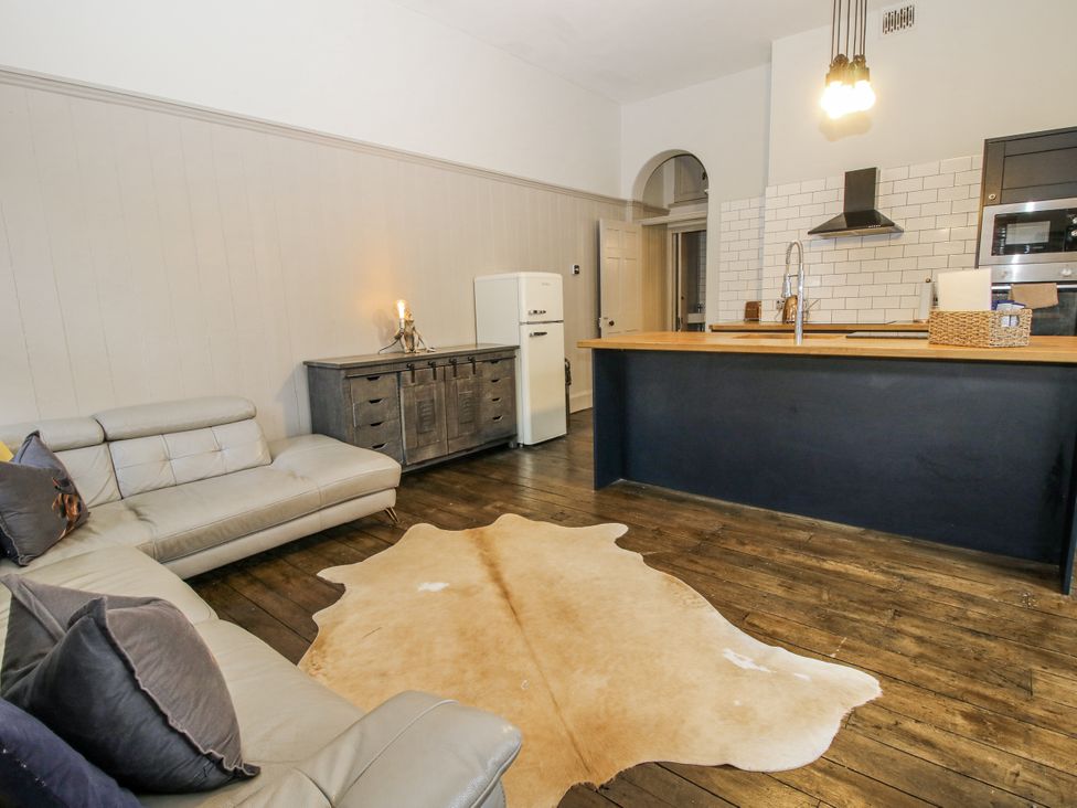 A living room with a kitchen island and seating area at 1C College Hill in Shrewsbury