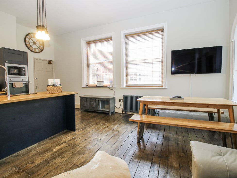 A living room with a kitchen island and dining table at 1C College Hill in Shrewsbury