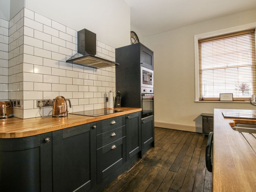 A kitchen with black cabinets and wooden countertop at 1C College Hill in Shrewsbury