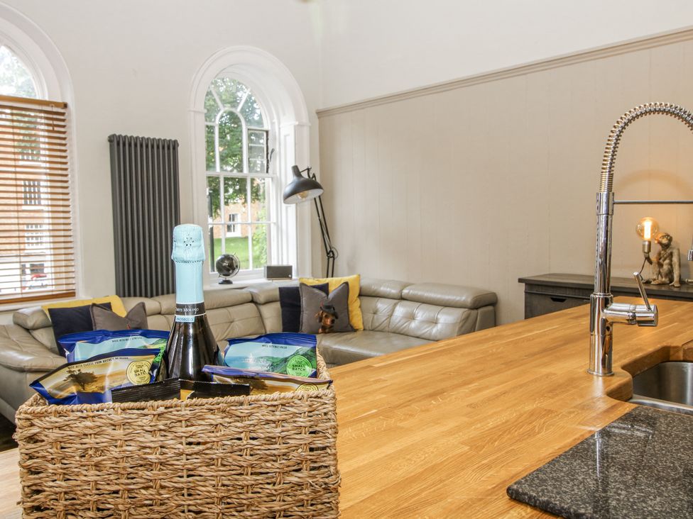 A living room with a sofa and a basket on a counter at 1C College Hill in Shrewsbury