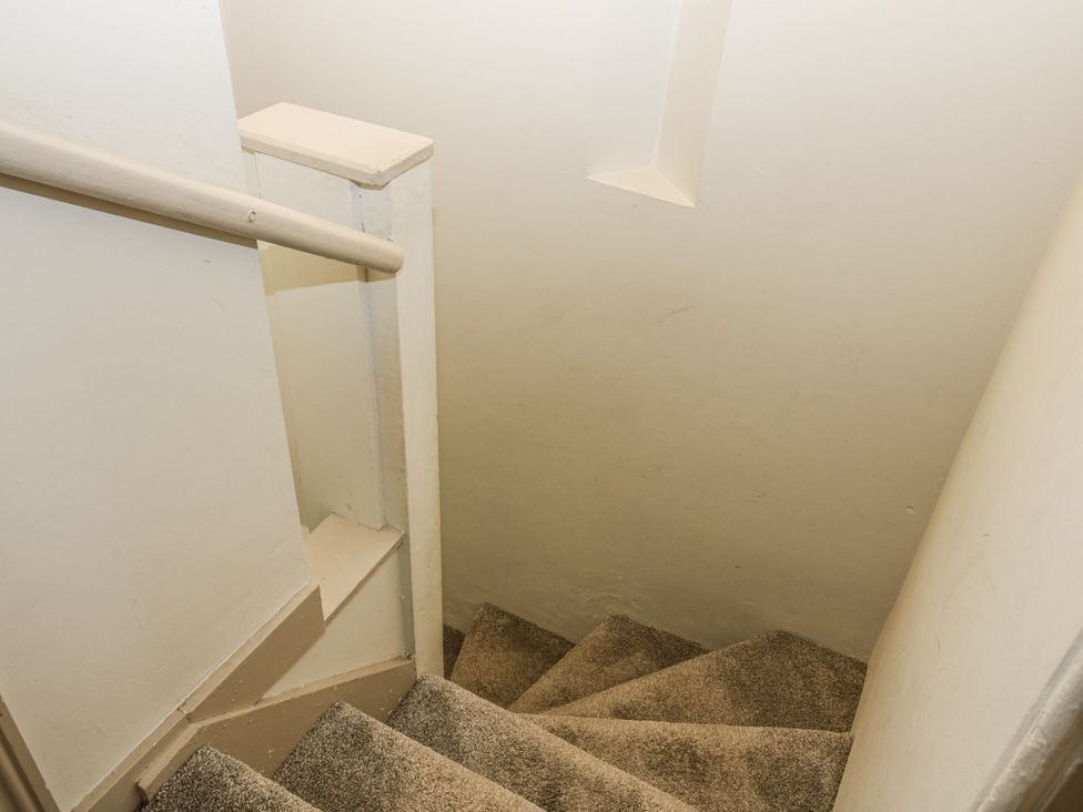 A staircase with carpet and handrail at 1C College Hill Shrewsbury