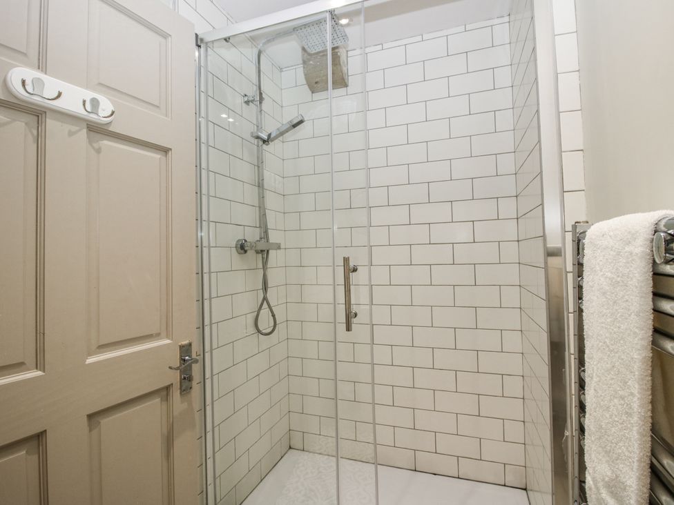 A shower with tiles and glass door at 1C College Hill Shrewsbury