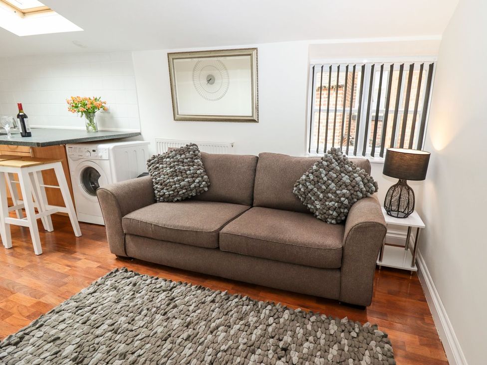 A living room with a sofa and washing machine at Bobby's in Whitby