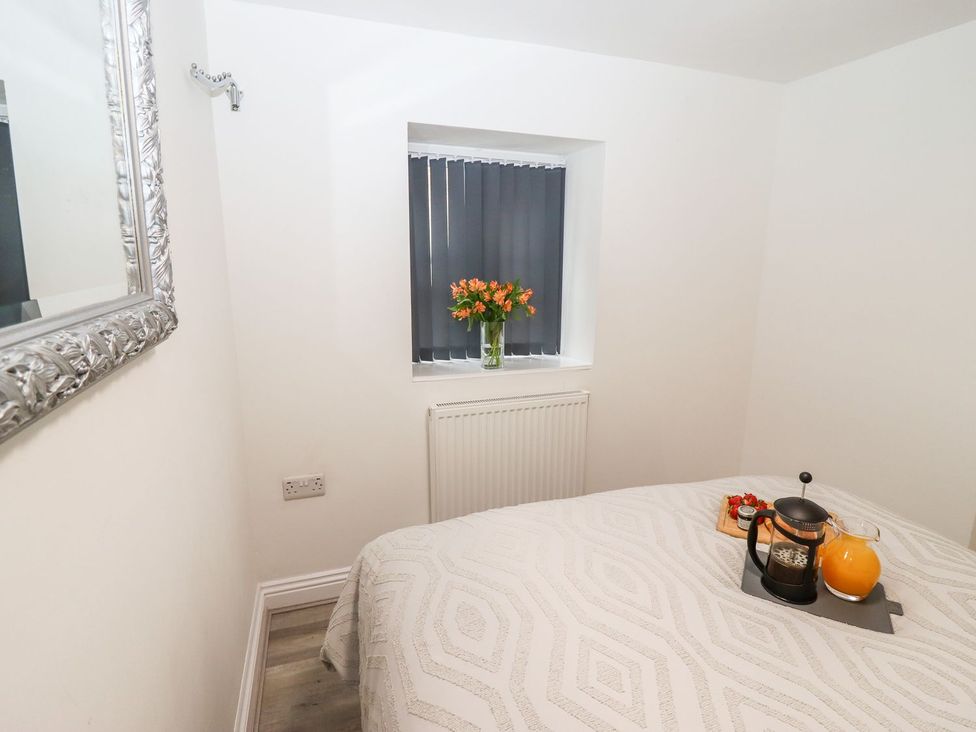A bedroom with a bed and tray on the side table at Bobby's in Whitby