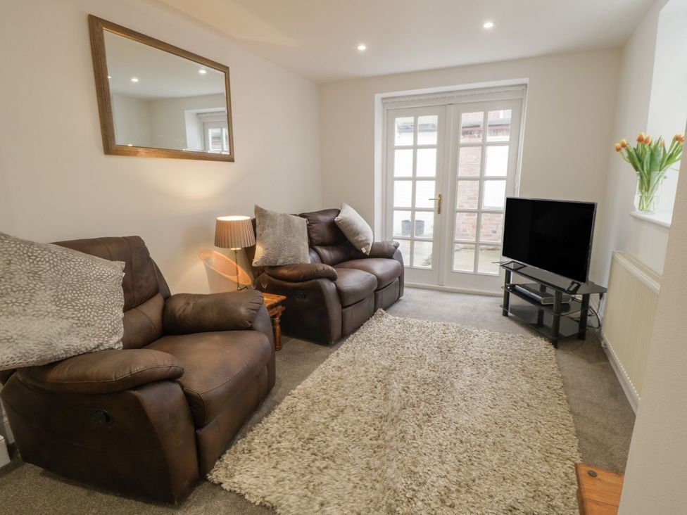A living room with sofas and a television at Ted's Place in Whitby