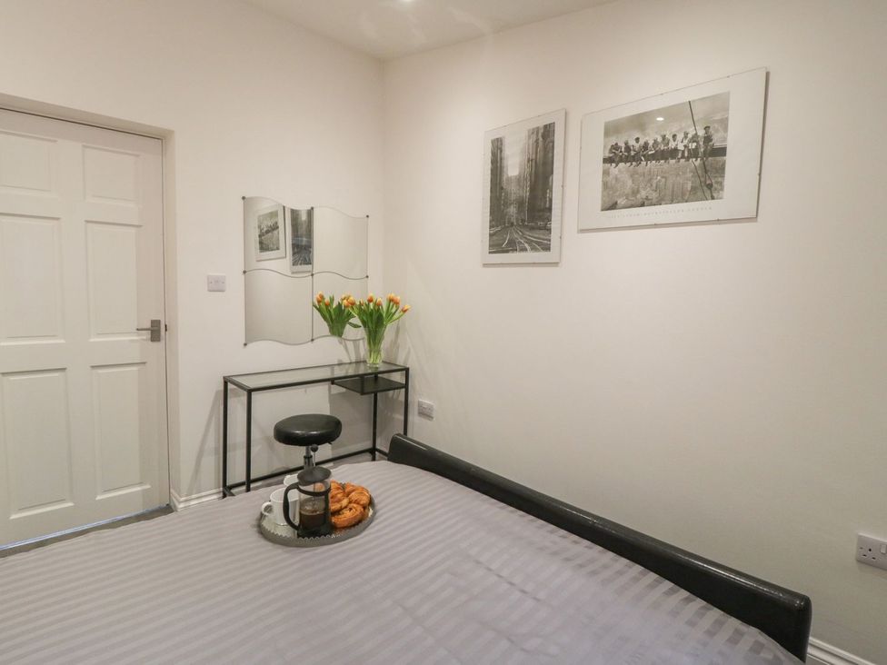 A bedroom with a bed, table, and flowers at Ted's Place in Whitby