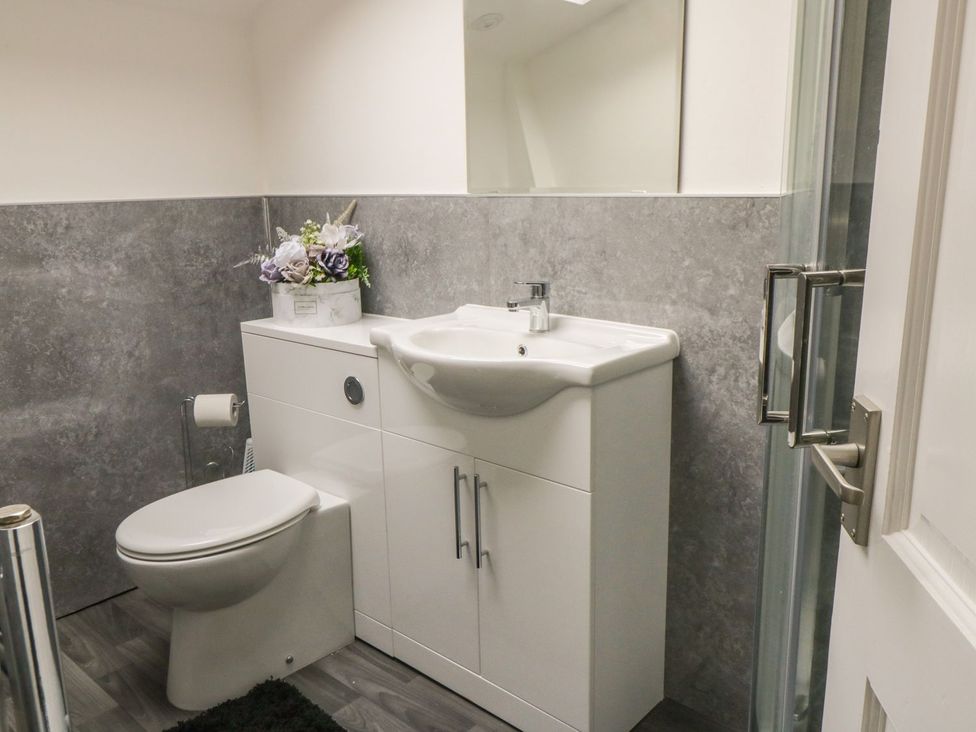 A bathroom with a toilet, sink, and shower at Ted's Place in Whitby