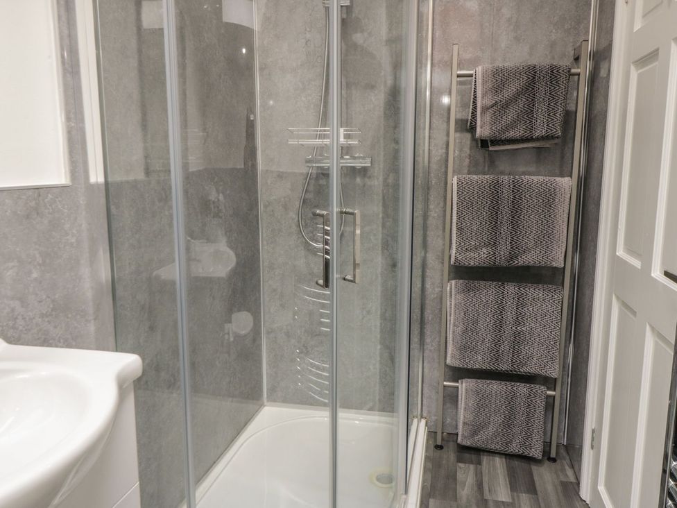 A bathroom with a shower and towels at Ted's Place in Whitby