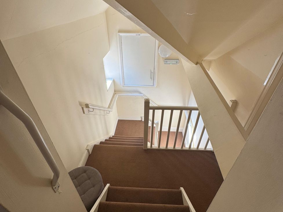 A staircase with a handrail and window at 31 High Street Telford