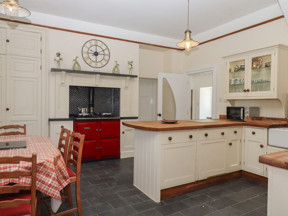A kitchen with a dining table and stove at Littleham Court Manor in Littleham near Bideford