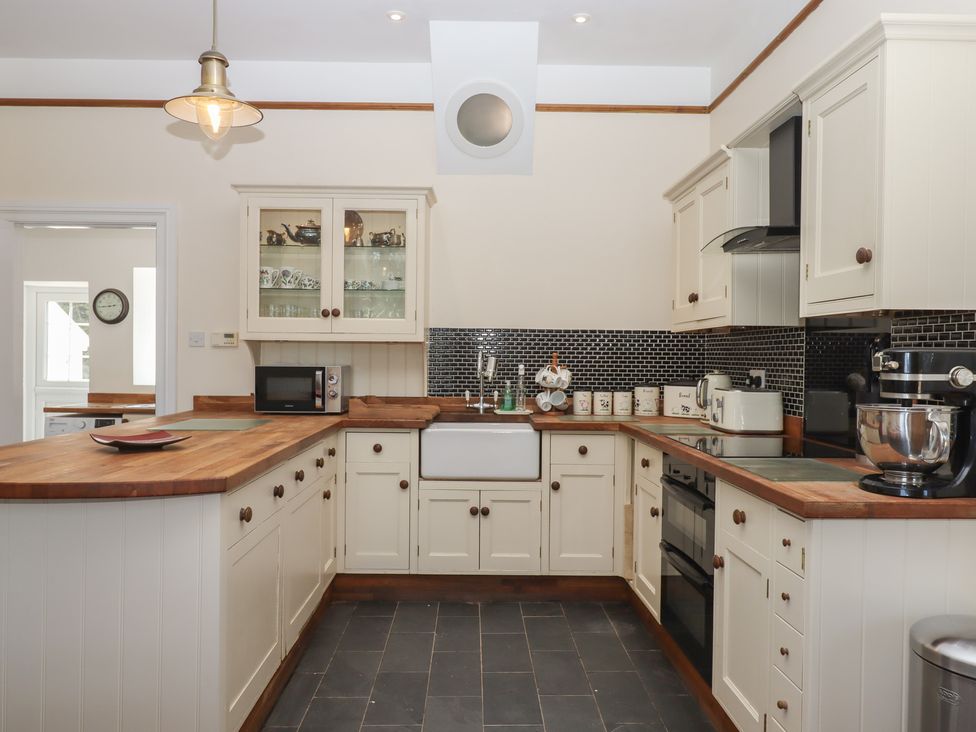 A kitchen with cabinets and appliances at Littleham Court Manor in Littleham near Bideford