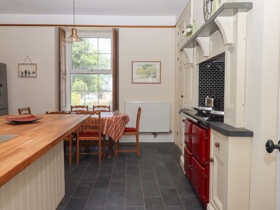 A kitchen with a dining table and refrigerator at Littleham Court Manor near Bideford