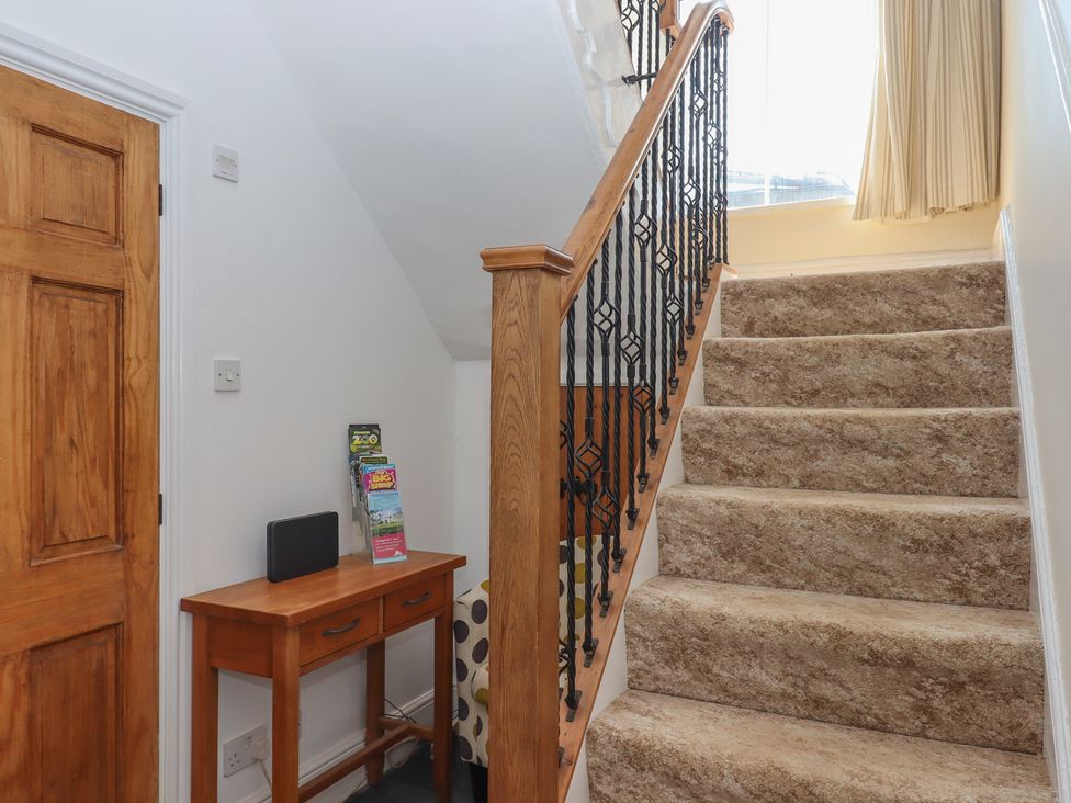 A hallway with a staircase and a console table at Littleham Court Manor Littleham near Bideford