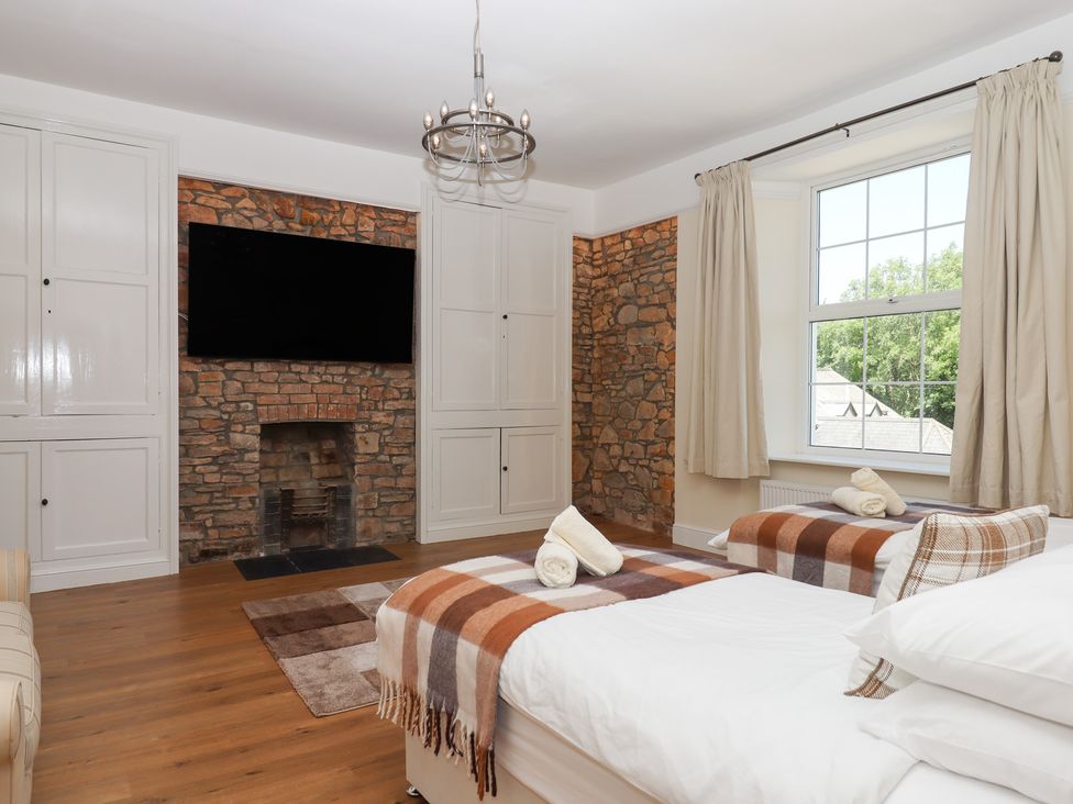 A bedroom with two beds and a television at Littleham Court Manor Littleham near Bideford