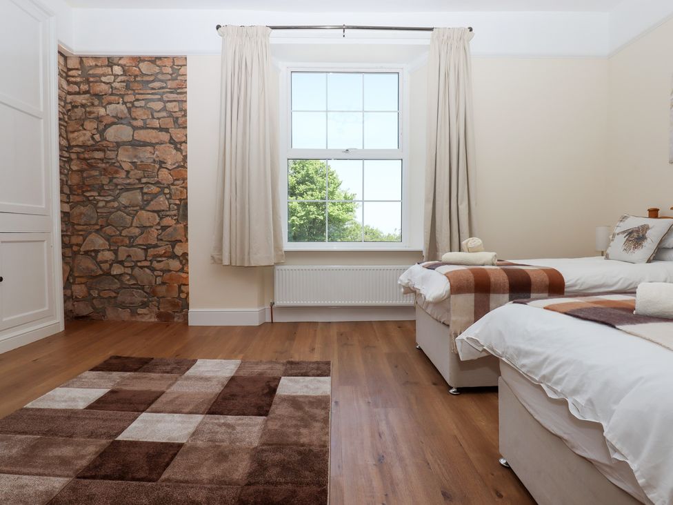 A bedroom with two beds and a window at Littleham Court Manor in Littleham near Bideford