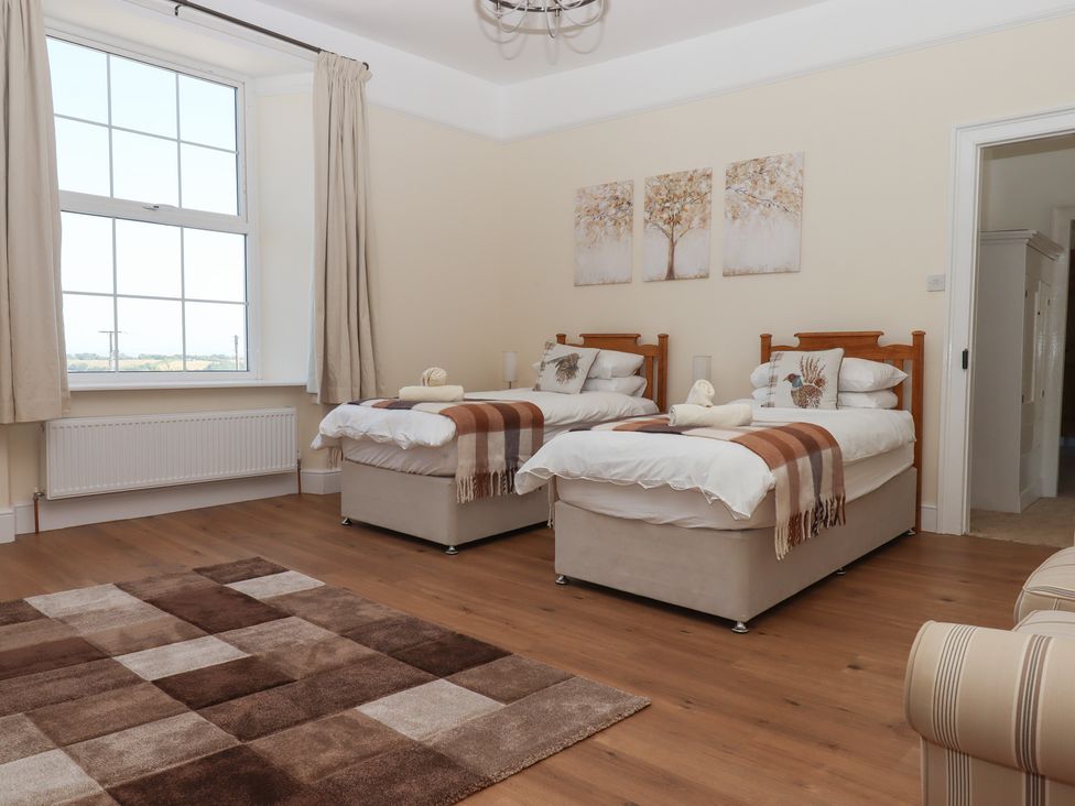 A bedroom with two beds and a window at Littleham Court Manor in Littleham near Bideford