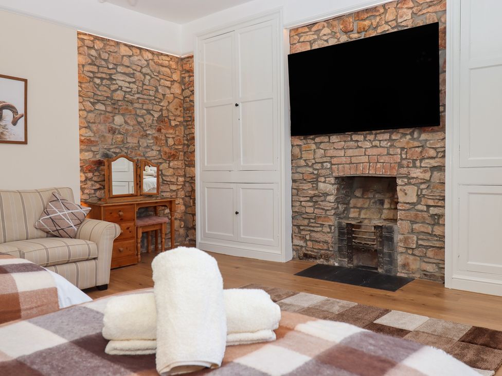 A bedroom with a sofa and television at Littleham Court Manor Littleham near Bideford