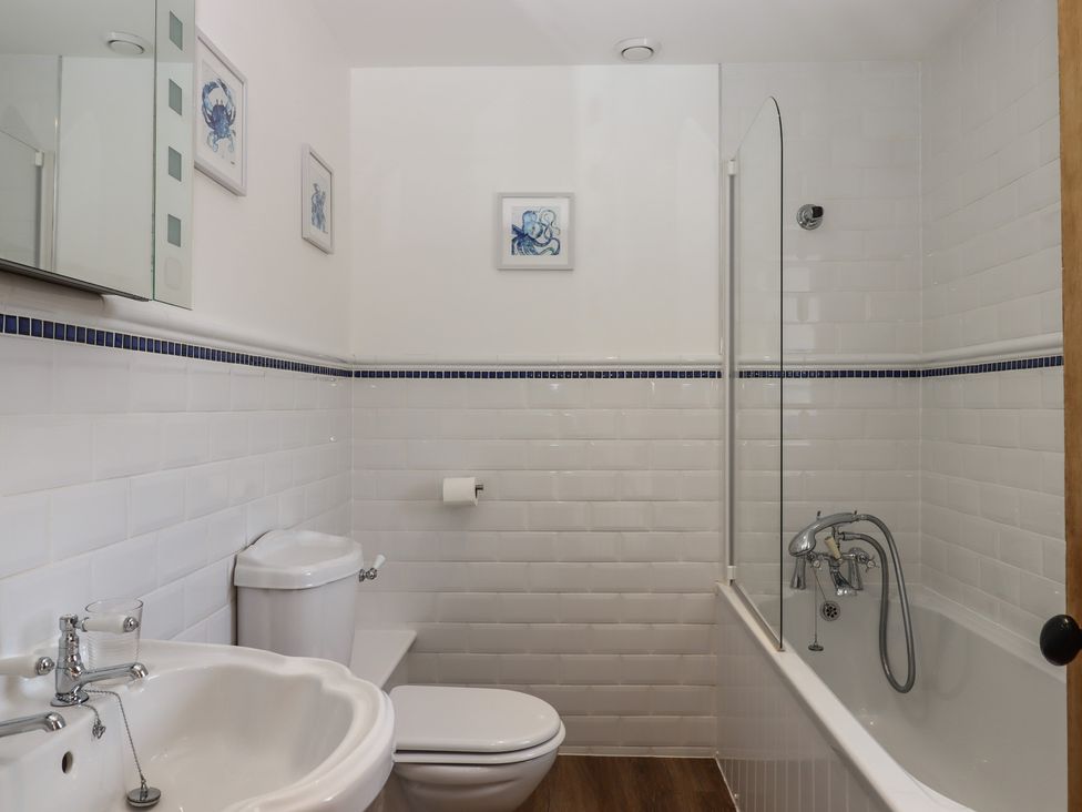 A bathroom with a bathtub, sink, and toilet at Littleham Court Manor in Littleham near Bideford