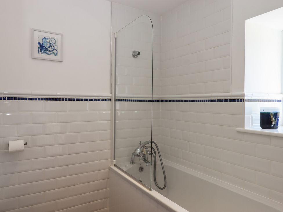 A bathroom with a bathtub and shower screen at Littleham Court Manor in Littleham near Bideford